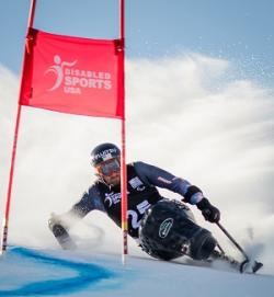 Paralympian skier Chris Devlin-Young rounding a barrier on his monoski