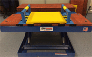 Figure 2. Figure 2 shows the transfer station used for all testing procedures with 6-inch grab bars attached to the station. The transfer station shown still consists of a hydraulic scissor lift and yellow cushion, as seen in Figure 1. However, the blue side guards that were placed on either side of the cushion have been replaced by grab bars. The grab bars run parallel to the sides of the cushion. 