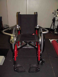 This figure shows the lap bar mounted to a wheelchair and a sensor module mounted to the lap bar. One photo shows the bar closed and one photo shows the bar opening and rotating about the clamps which are attached to the backrest of the chair.