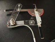 This photo shows the details of the parallelogram linkage that comprises the knee goniometer.  Two arms of the parallelogram linkage are comprised of a commercial mechanical goniometer.  The two other arms of the parallelogram are custom made.  The potentiometer is placed at the juncture of these two custom made arms.