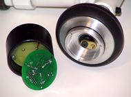  The photograph shows a miniature data logger which is about the size of a baby food jar.  The plastic enclosure has been opened; the PC board has been removed from the aluminum base and turned over so that the three miniature reed switches are visible.  Within the aluminum base is a brass arm.  One end of this arm is attached to the caster axle; similar to a clock hand. At outer end of the arm is mounted a pill-size magnet.   The arm remains stationary while the data logger and caster rotate around the fixed position magnet.
