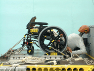 This figure shows two post-test images of wheelchairs that have been tested to the proposed rear-impact standard.  Both wheelchair have catastrophic seatback failures and show the crash test dummy no longer seated in the wheelchair. 