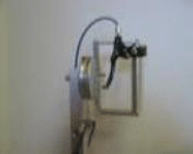 This is a photo of the user interface at the top end of the lever.  The photo is taken from the side of the wheelchair.  It shows the cylindrical handle that is used for propulsion.  When the handle is turned it steers the front caster.  The brake lever attached to the handle is also shown.  