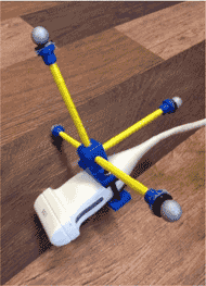 Figure 1: Picture of custom ultrasound probe. This is a standard ultrasound scanning probe that is fitted with a custom orthogonal attachment. This attachment consists of four rods, one pointing to the left of the probe, one to the right, one upward, and one backward that are each fitted with a Vicon marker. These markers allow the Vicon camera system to track the location of the ultrasound probe during scanning.  