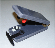Figure 4 is a photo stapler type device approximately the size of a cell phone with the completed post assemblies positioned in the grooves in the base of the device. 