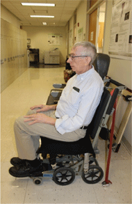 Figure 1 Left is a side view of a non-ambulatory man seated in a Columbia Aislemaster boarding chair. This chair has fold up arm supports, but they are often too narrow for user fit and comfort.