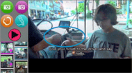 Figure 1 depicts a video VSD app screenshot from the bus riding activity. The left side of the screen contains 4 programming buttons, including: capture a photo, capture a video, make a hotspot, and draw. It also contains the play button that is used to play videos. Below the programming icons, there is a menu that contains thumbnails of videoVSDs within the bus riding activity. The video that is currently playing is highlighted with a pink border. To the right of the programming icons and navigation menu, the right part of the screen contains the video VSD. This particular video VSD depicts the participant handing her ticket to the bus driver. There is a hotspot, which is depicted as blue circle, over the action of handing the ticket. The hotspot contained the embedded message “hello” used to greet the bus driver. At the bottom of the video VSD screen, there is a short text caption that describes the step. It reads: Give your ticket to the bus driver and say hello. 