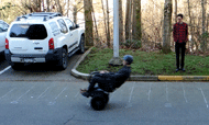 Photo looking down at the parking lot area used for the braking test. The user is seated on the Nino® leaned backward, mid emergency braking maneuver. Marks are made on the asphalt to indicate starting and stopping distance.