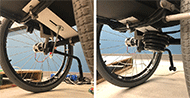 The left image shows the Dibond metal shelf structure comprising the system to mount weights at the center of mass location. The 5” wide shelf suspends from two horizontal supports under the seat of the wheelchair. A slot or channel is cut down the midline of the shelf with enough room for a long bolt to slide through. It is fastened to the shelf by tightening the nut to lock itself in position. The right image shows 5 cylindrical weights totaling +4 kg mounted on the bolt protruding from the shelf. A nut and washer constrain the weights to the bolt and fix their position on the shelf. 