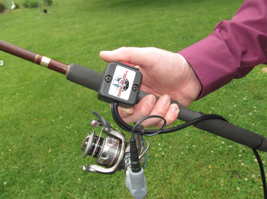 Hand holding a fishing rod with a battery attached to power reel.