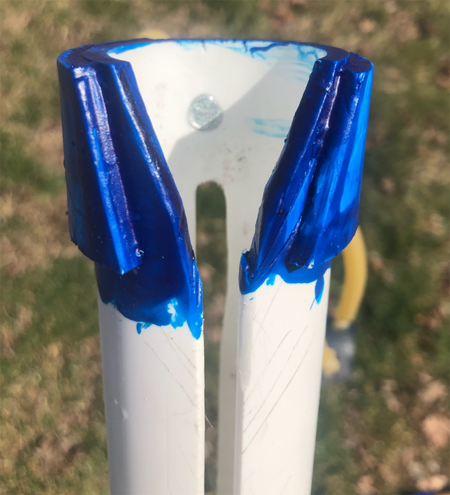 Blue end of PVC pipe with V shape cut out of the end for firing end of launcher. 