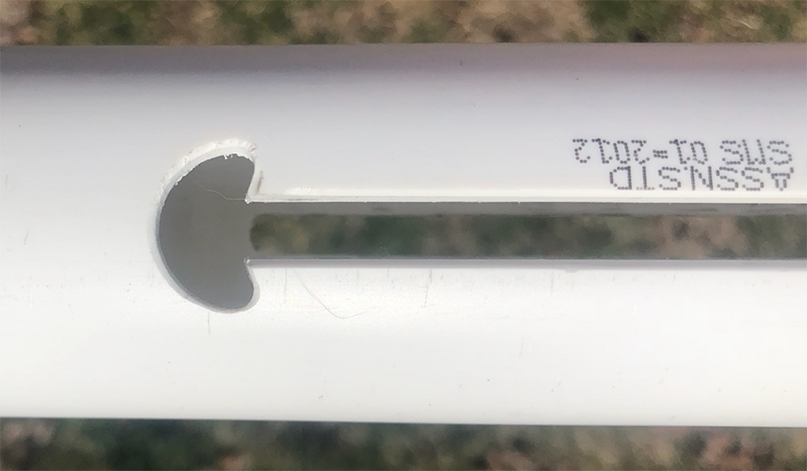 White PVC pipe with mushroom shape cut out at end of slot for trigger holding mechanism.