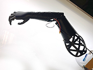 This image of the Knack prosthesis shows the current development of the arm and hand unit, featuring a contoured form, cutouts for breathability, incorporation of motorization and compliant design