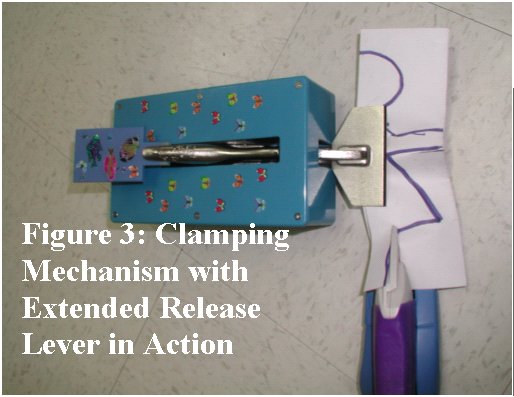 Figure 3 shows the paper clamp with the blue extended release lever protruding from the blue plastic enclosure. A paper doll outline is securely grasped in the mouth of the paper clamp. The rubber teeth in the clamp mouth create a visible corrugated effect on the paper to permit the electric scissors to cut the pattern as shown. 