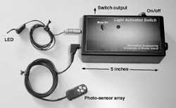 Photograph of a prototype showing a box containing the electronics and two leads connecting to the LED and the photo-sensor array. 