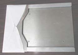 Image shows the top view of the 9 x 4 envelope inserting aid with an envelope mounted. The tray is 8 x 8.6 with two perpendicular lipped edges. The triangular cut in the top piece of the channel conforms closely to the envelope opening. 