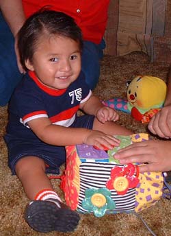 Diagram shows the smiling client playing with a music cube. 