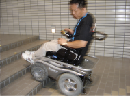 Pictures of two wheelchair users demonstrating driving with the “Patrafour” over  2inch obstacles-one obstacle is a step and the other obstacle  is a piece of wood