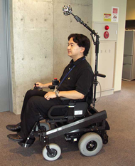 This image provides an external view of the electric wheelchair prototype. The positioning of the SOS above and forward of the user’s head offers the following advantages: (1) a wide observation range can be provided, without blind spots in the electric wheelchair’s surroundings; (2) there is no hindrance to getting in and out of the wheelchair; and (3) the SOS is positioned at approximately body height, thereby providing clearance in normal living spaces.