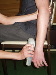 Part 2 shows the therapist placing the Goniometer on a bony landmark at the patient’s wrist.