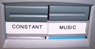 Image displays AV selector switch utilized to transition between constant vibration and music-synchronized vibration.  The selector has two buttons labeled “Constant” and “Music.”