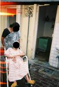 Figure 2 shows an example of the image taken by the subjects in India.  It shows an older woman in a depot style wheelchair at her residence.  Someone is standing behind her aiding her in some way.  It is notable that the quality of the photo is not very good.  Also, the accessibility issue the subject is trying to convey is not very clear.  These are common features of the photos throughout the dataset.