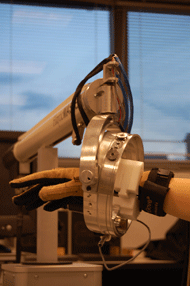 This photo shows the robot with special haptic features ang the ring attached to it which allows wrist pronation and supination. The set of two brings six-degrees of freedom movement and the robot can control four of them (i.e., x, y, z and roll) thru servomotors. 