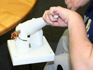 This photograph shows the left hand position of P3, who has cerebral palsy, grasping the laser joystick. P3 has internal rotation of her shoulder and also flexion in her wrist. 