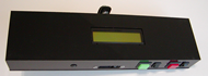 This is a picture of the top of the device, and shows the LCD screen mounted in the top faceplate of the device, diagnostic switches for the laser and motor (bottom right) and cutout for the distance sensor (bottom, center). 