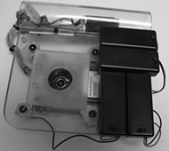 Figure shows an image of the device from the bottom side. Batteries for LEDs and laser diodes can be seen mounted to the docking station (see figure 1). Laser diodes are arranged in a square with the camera lens centered in the four. 8 LEDs used for scene illumination circle the camera lens at a smaller radius than the LEDs. These LEDs are covered by a diffusion filter. The diffusion filter has its center cut out as to not obscure the camera’s field of view. 