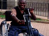 This figure shows a handcycle user testing the Figure-Eight Drive on one of the inclines in the APDK compound.  He is climbing the hill in the low gear by pedaling in reverse, and appears visibly pleased by the drivetrain’s performance. 