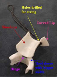The image shows the second design.  The shoehorn (red) has been modified from Photo 4 in that it is much wider to better fit our client’s heel.  The shoehorn also has a curved lip attached to its top (pink arrow).  The lip sticks out at a 90 degree angle to the outside of the shoehorn and has holes drilled into it for the string (yellow).  The last modification to the shoehorn from the previous prototype is its attachment to the heel sleeve. The heel sleeve (blue) connects by a hinge (purple) to the bottom of the shoehorn.  Lastly, the heel sleeve has been modified to have a bigger width to fit around the shoe.