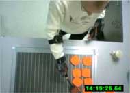 Image shows an investigator engaged in the simulated burger flipping task as data is being collected regarding performance via accelerometers and an overhead camera to further refine and train the system. 