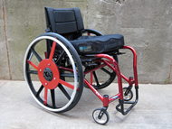 Figure shows the Invacare A4 chair with the prototype “mag” wheel installed.  The push rim engages the brake pads via a rotational member attached to the hub of the wheel.