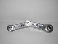 Slots were milled in these fasteners to allow a screw to pass through.  Movement of the slots allows the length of the crank arm sections to be adjusted relative to one another. The screws can be tightened, fixing a new length for each section. This creates an adjustable-length crank arm that can be customized for any individual. 
