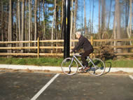 The above photo shows our client riding on flat, paved ground.  Her left foot is approximately at the top of the pedal cycle, meaning she is flexing her left knee to her maximum in the photo.    Otherwise, the client appears to be riding a typical bike. 