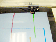 This picture is a close-up of the iPad screen showing vertical and horizontal lines drawn in different colors using the Mechanical Cross Scanner to operate the Doodle Buddy drawing App. 